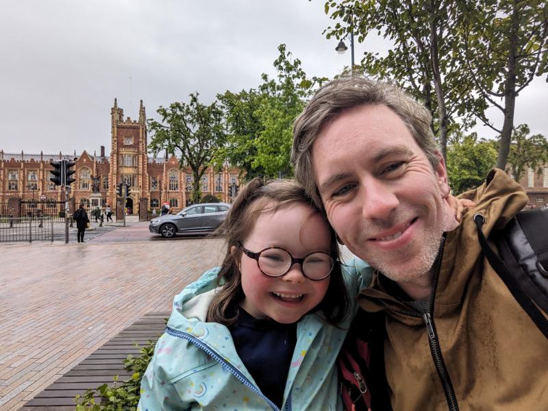 Dermot Leonard with his daughter standing opposite Queen's University Belfast
